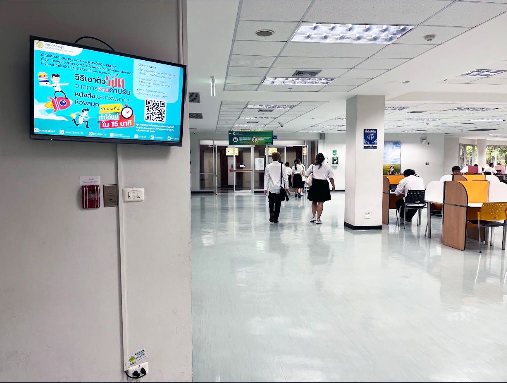 Pantallas de cartelería digital instaladas sobre las puertas del ascensor en el tercer piso de la Biblioteca de la Universidad Kasetsart, que llegan a cada estudiante que espera para subir entre pisos.