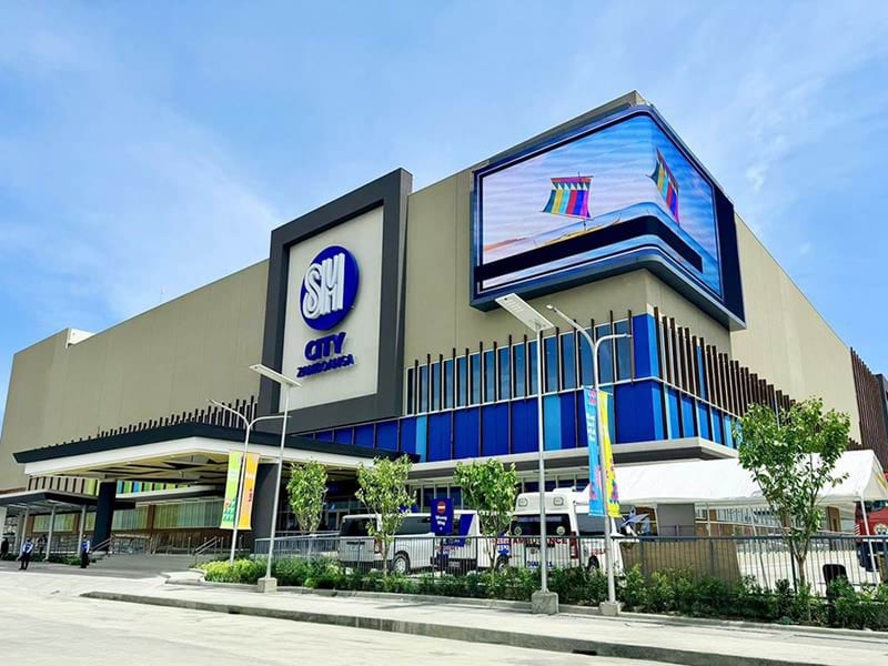 Le mur LED extérieur courbe de SM City Zamboanga ancre la façade du bâtiment et prolonge la présence visuelle du centre jusqu'à l'espace urbain environnant de Zamboanga City.